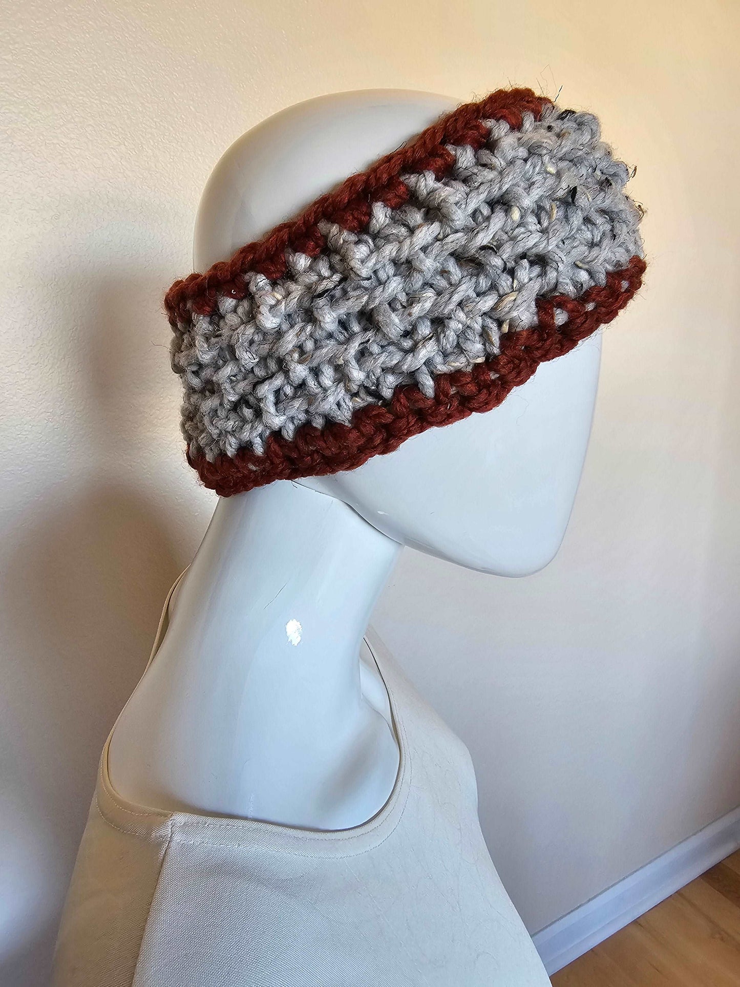 Chunky crochet headband in deep red and gray tweed. Wool acrylic blend for easy care. Adult size. Shown from side on mannequin.